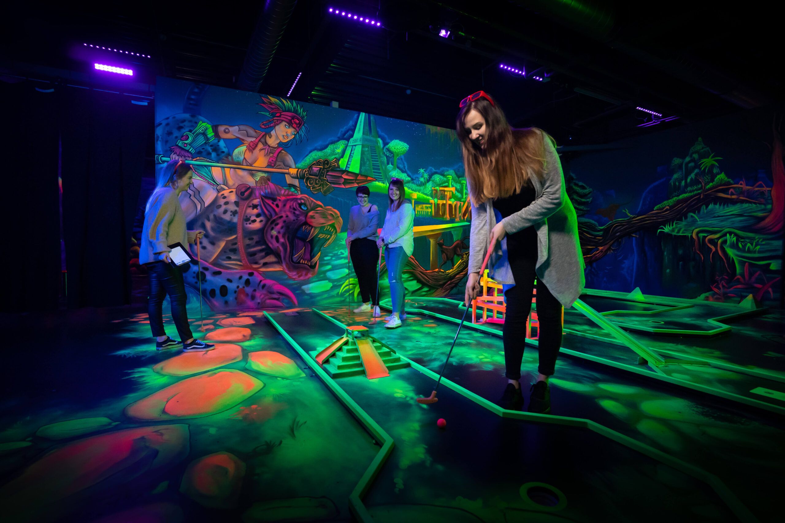 Frau spielt Minigolf in Essen bei Schwarzlicht und in 3D